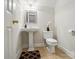 Clean, minimalist bathroom with pedestal sink, toilet, and decorative mirror at 3011 Patrick Place Cir, Clover, SC 29710