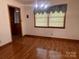 Dining area with hardwood floors, a modern light fixture, and a large window at 309 E Stevens Rd, Kershaw, SC 29067