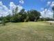 View of a grassy parcel of land surrounded by mature shade trees on a sunny, blue sky day at 309 E Stevens Rd, Kershaw, SC 29067