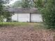 Detached garage with a roll-up door surrounded by mature trees and foliage at 309 E Stevens Rd, Kershaw, SC 29067