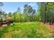 Expansive backyard with a manicured lawn, mature trees, a wooded area, and an outdoor dining area at 3095 Foggy Hollow Ln, Clover, SC 29710