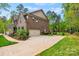 Brick home with a two-car garage, a well-manicured lawn, and mature trees in the background at 3095 Foggy Hollow Ln, Clover, SC 29710