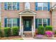 Charming front entryway with brick facade, blue door, and colorful landscaping, showcasing a welcoming entrance at 3095 Foggy Hollow Ln, Clover, SC 29710
