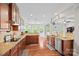 Well-lit kitchen features dark wood cabinets, granite countertops, stainless appliances, and hardwood flooring at 3095 Foggy Hollow Ln, Clover, SC 29710