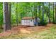 Backyard storage shed surrounded by mature trees and greenery on a well maintained lawn at 3095 Foggy Hollow Ln, Clover, SC 29710