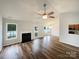 Open-concept living room with vaulted ceiling, fireplace, and natural light, flowing into the dining area at 4147 Timberwood Dr, Gastonia, NC 28056