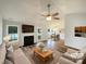 Bright, virtually staged living room features a fireplace, ceiling fan, and open concept design into the dining area at 4147 Timberwood Dr, Gastonia, NC 28056