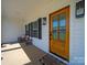 Covered porch boasts rocking chairs, a wood door, stylish light fixtures, and views of the neighborhood at 4189 Brandy Creek Ct, Clover, SC 29710