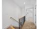 Hallway with wooden stairs, dark banister, and a view into a naturally lit room at 4189 Brandy Creek Ct, Clover, SC 29710
