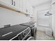 Well-equipped laundry room with modern machines, ample cabinet space, and stylish tile flooring at 4189 Brandy Creek Ct, Clover, SC 29710