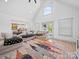 Bright living room with a high ceiling, large windows, and hardwood floors, flowing to an outdoor deck at 4189 Brandy Creek Ct, Clover, SC 29710