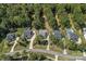 Aerial view of houses with well-manicured lawns and swimming pools, nestled among mature trees at 4195 Island Fox Ln, Denver, NC 28037