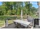 Back deck featuring an outdoor dining table, chairs, umbrella, and grill overlooking the fenced backyard at 4195 Island Fox Ln, Denver, NC 28037
