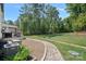 Backyard featuring a stone walkway leading to home, grass and bordered by mature trees at 4195 Island Fox Ln, Denver, NC 28037