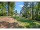 Landscaped backyard featuring a large grass area and mature trees at 4195 Island Fox Ln, Denver, NC 28037