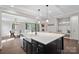 Open-concept kitchen with a large island featuring a farmhouse sink and modern pendant lighting at 4195 Island Fox Ln, Denver, NC 28037