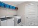 Clean laundry room with washer, dryer, storage shelving, and a door at 4195 Island Fox Ln, Denver, NC 28037