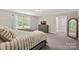 Bright main bedroom featuring a large window, dresser with TV and neutral tones at 4195 Island Fox Ln, Denver, NC 28037