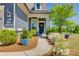 Inviting front porch with decorative plants, a welcoming wreath, and a cozy walkway at 4502 Middlebury Ln, Fort Mill, SC 29715