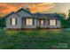 Charming single-story home features gray siding, a well-manicured lawn, and inviting curb appeal at sunset at 4773 Westwinds Rd, Lincolnton, NC 28092