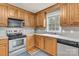 Efficient kitchen with stainless steel appliances, wood cabinets, and a well-lit sink area at 4773 Westwinds Rd, Lincolnton, NC 28092