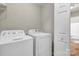 Functional laundry room features a washer and dryer, with a glimpse of the bathroom beyond the open door at 4773 Westwinds Rd, Lincolnton, NC 28092