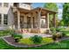 Covered back porch featuring brick columns, wood ceiling, and beautifully landscaped garden at 4904 Ardenetti Ct, Mint Hill, NC 28227