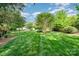Expansive backyard with lush green grass, mature trees, and a view of the beautiful home at 4904 Ardenetti Ct, Mint Hill, NC 28227