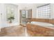 Bright bathroom with a soaking tub, a walk-in shower, tile floors and a large window at 4904 Ardenetti Ct, Mint Hill, NC 28227