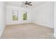 Spacious bedroom with neutral carpet, ceiling fan and two windows at 4904 Ardenetti Ct, Mint Hill, NC 28227