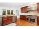 A bright kitchen features stainless steel appliances, granite countertops, dark cabinets, and hardwood floors at 4904 Ardenetti Ct, Mint Hill, NC 28227