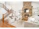 Open concept living room with a stone fireplace, wood floors, large windows, and a staircase to the upper level at 4904 Ardenetti Ct, Mint Hill, NC 28227