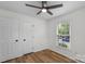 Bedroom featuring wood flooring, ceiling fan, and a window for natural light at 4932 Delivau Dr, Charlotte, NC 28215
