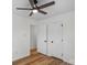 Bedroom featuring wood flooring, ceiling fan, and two doors at 4932 Delivau Dr, Charlotte, NC 28215