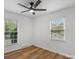 Bright bedroom with hardwood floors, a ceiling fan, and two windows for natural light at 4932 Delivau Dr, Charlotte, NC 28215