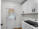 Laundry room with door, white washer, and white cabinets at 4932 Delivau Dr, Charlotte, NC 28215
