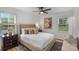 Comfortable primary bedroom features plush bedding, bedside table and ceiling fan at 4932 Delivau Dr, Charlotte, NC 28215