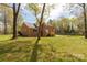 Back exterior of the brick home with wooden deck, large trees, and green grass at 605 Ottawa Dr, Rock Hill, SC 29732