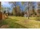 Large backyard with green grass, mature trees, and a storage shed at 605 Ottawa Dr, Rock Hill, SC 29732