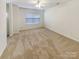 A comfortable bedroom featuring carpet, a ceiling fan, and a window with blinds, perfect for relaxation at 6525 Soapstone Dr, Charlotte, NC 28269