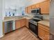 Modern kitchen with stainless steel appliances, wooden cabinets, and wood-look flooring at 6525 Soapstone Dr, Charlotte, NC 28269