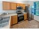 Functional kitchen with stainless steel appliances, light wood cabinets, and laminate flooring at 6525 Soapstone Dr, Charlotte, NC 28269
