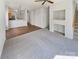 A cozy living room featuring hardwood and carpet flooring, leading to a glimpse of the kitchen with modern pendant lighting at 6525 Soapstone Dr, Charlotte, NC 28269