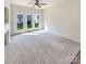 Bright living room featuring carpet and sliding glass doors leading to the backyard at 6525 Soapstone Dr, Charlotte, NC 28269