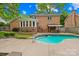 A refreshing pool, a charming bar area, and the brick-clad exterior create a perfect blend of luxury and cozy outdoor living at 6744 Wheeler Dr, Charlotte, NC 28211