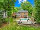 A backyard featuring a pool and manicured lawn, surrounded by large trees at 6744 Wheeler Dr, Charlotte, NC 28211