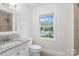A simple bathroom featuring a toilet and a granite topped vanity at 6744 Wheeler Dr, Charlotte, NC 28211