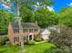 Beautiful brick two-story home with lush landscaping, mature trees, and attached garage, creating a welcoming curb appeal at 6744 Wheeler Dr, Charlotte, NC 28211