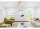 Bright living room featuring hardwood floors, a modern ceiling fan, and comfortable seating arrangement at 6744 Wheeler Dr, Charlotte, NC 28211
