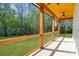 Spacious covered porch with wood pillars and a view of the lush, green yard at 7205 Church Rd, Taylorsville, NC 28681